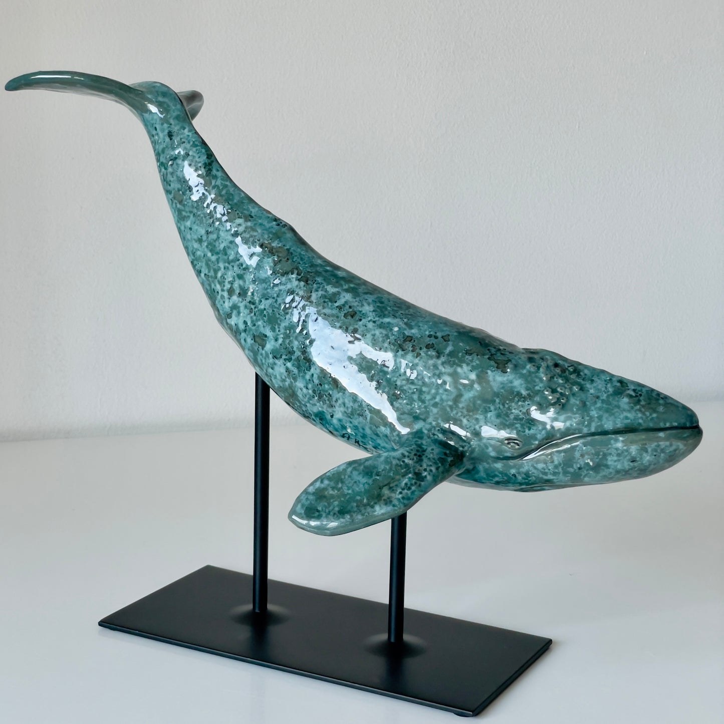 Gray whale sculpture on a metal stand
