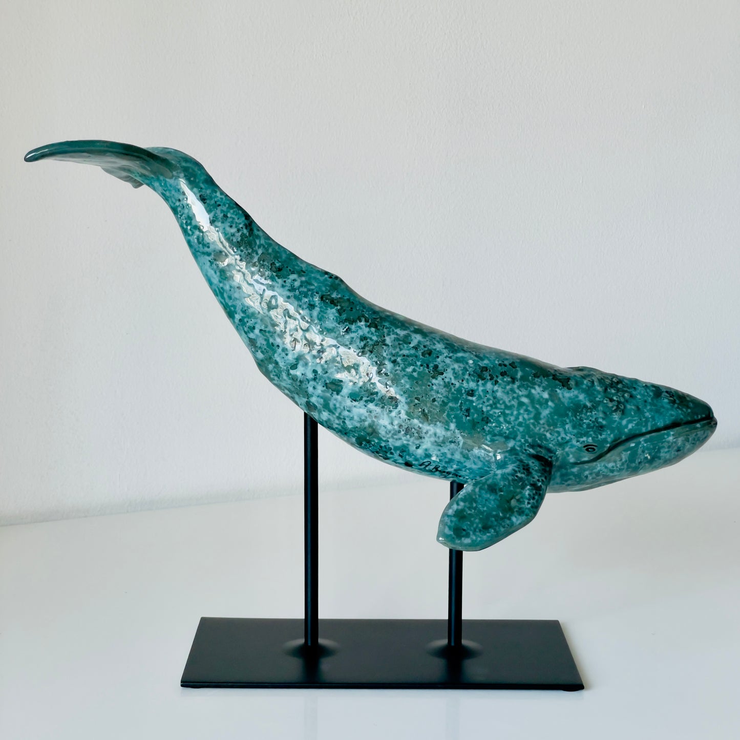 Gray whale sculpture on a metal stand